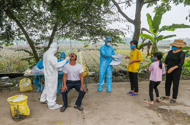 Khi mẫu về, toàn bộ các phòng thí nghiệm của CDC Hà Nội làm việc 24/24 giờ, chia 4 ca liên tục. Tất cả vì mục tiêu mẫu bệnh phẩm phải được xét nghiệm ngay, trả kết quả sớm nhất, chính xác. Ảnh: CDC Hà Nội lấy mẫu xét nghiệm COVID-19 ở "ổ dịch" thôn Hạ Lôi.