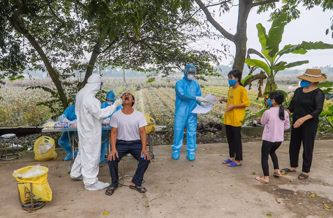 Khi mẫu về, toàn bộ các phòng thí nghiệm của CDC Hà Nội làm việc 24/24 giờ, chia 4 ca liên tục. Tất cả vì mục tiêu mẫu bệnh phẩm phải được xét nghiệm ngay, trả kết quả sớm nhất, chính xác. Ảnh: CDC Hà Nội lấy mẫu xét nghiệm COVID-19 ở "ổ dịch" thôn Hạ Lôi.