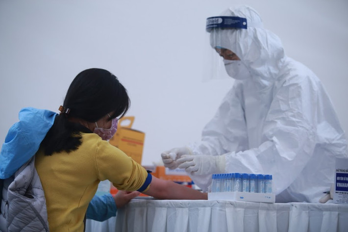 Các bác sĩ lấy mẫu máu người dân để xét nghiệm nhanh COVID-19.