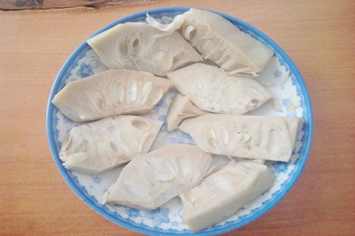 Cách làm mít non kho tộ: Mít non mua về bạn rửa sạch, cắt thành từng khổ vừa ăn. Đun nước sôi và luộc chín mít. Bạn cũng có thể mua mít non luộc sẵn. Cắt mít thành từng miếng vừa ăn. Cho mít vào bát lớn và ướp gia vị. Cho 2 muỗng đường, 1 muỗng muối, 2 muỗng bột nêm chay, vài giọt dầu màu dừa, nhiều tiêu, 3 muỗng nước tương, 1/2 muỗng ớt bột . Trộn đều cho mít thấm gia vị.