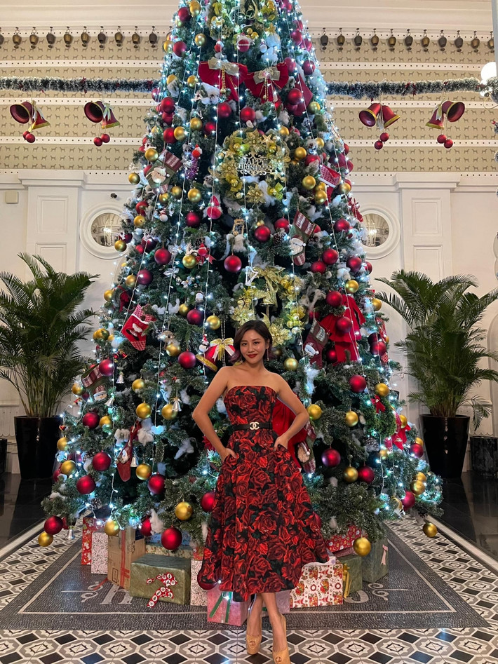 Văn Mai Hương diện váy của NTK Đỗ Mạnh Cường cùng thắt lưng Chanel tạo dáng bên cây thông Noel.