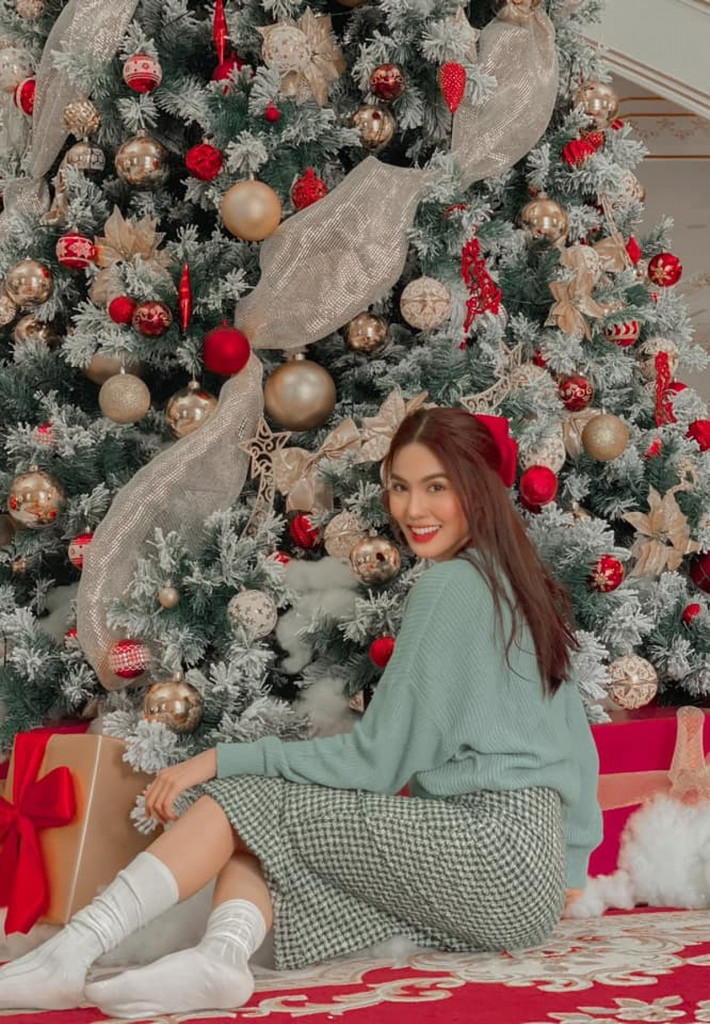 Lan Khuê được khen ngày càng xinh đẹp và nhuận sắc sau khi sinh con đầu lòng. Người đẹp diện chân váy kẻ đơn giản, áo len màu xanh bạc hà, đánh son đỏ bên cây thông Noel trang trí cầy kỳ tại nhà.