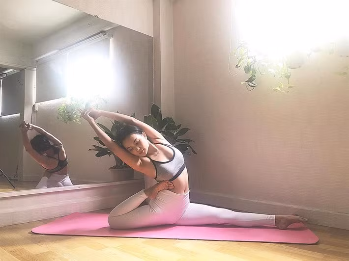 Sĩ Thanh thực hiện thuần thục tư thế bồ câu vua một chân. Động tác này giúp người tập duỗi cơ đùi, bụng, mông, thư giãn vai, ngực, kích thích tiêu hóa.