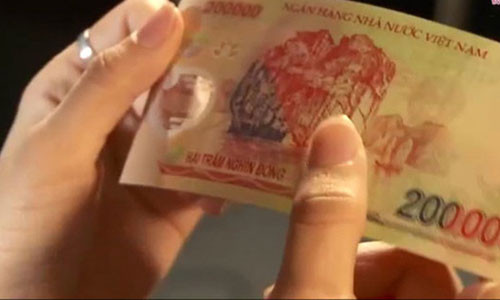 Hình ảnh kiểm tra tiền giả - thật - Ảnh chụp từ clip của báo Tuổi Trẻ. Hình ảnh kiểm tra tiền giả - thật - Ảnh chụp từ clip của báo Tuổi Trẻ.