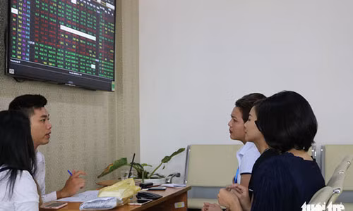 Các nhà đầu tư trao đổi tại một sàn giao dịch chứng khoán ở quận 1, khi thị trường chứng khoán hồi phục nhẹ vào đầu giờ chiều - ẢNH : TRẤN KIÊN