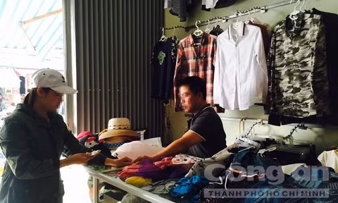 Anh Minh đang bán thanh lý số quần áo ở cửa hàng để lấy tiền trả nợ.