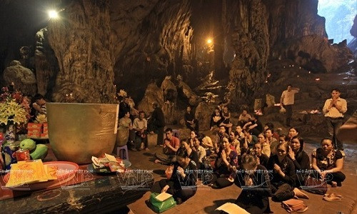 Phật tử bái lễ Bồ tát Quan Thế Âm trong động Hương Tích mong cho một năm mới may mắn. (Ảnh: Báo Ảnh Việt Nam/TTXVN)