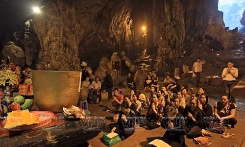 Phật tử bái lễ Bồ tát Quan Thế Âm trong động Hương Tích mong cho một năm mới may mắn. (Ảnh: Báo Ảnh Việt Nam/TTXVN)