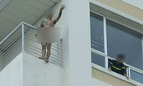 Thanh niên đứng ngoài lan can của lầu 10 bệnh viện Đa khoa Đồng Nai. Ảnh: VH.