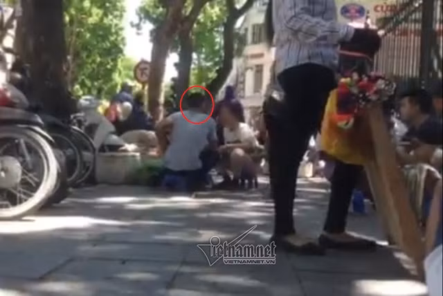 "Cò" môi giới trao đổi với phóng viên về việc mua bán tinh trùng ở cổng bệnh viện Phụ sản Trung ương.