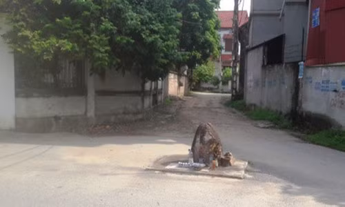 Hòn đá nằm giữa ngã ba của làng Vèo nhưng không ai dám động tới (Ảnh: Đào Tấn).