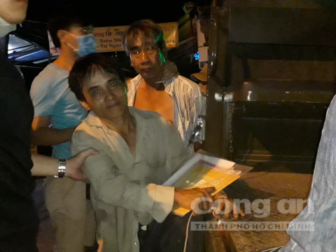 Người đàn ông bị áp giải lên xe tội phạm do tham gia đánh bạc tại quán cà phê Sóng Nhạc, trên tay còn cầm xấp hồ sơ xét tuyển lên trung học cơ sở của con gái mình