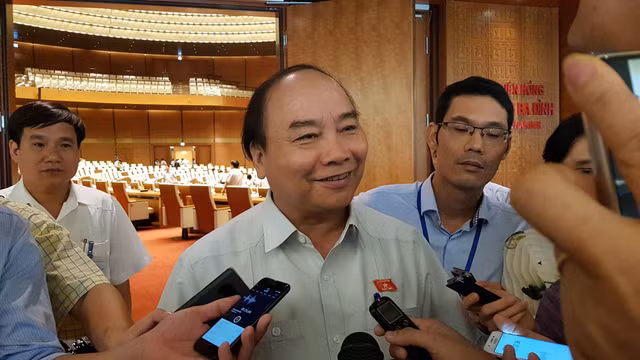 Thủ tướng trao đổi với báo chí bên hành lang Quốc hội.