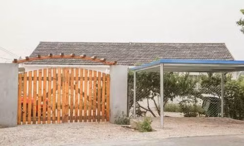Cô sử dụng chất liệu gỗ làm cổng chính cho nhà và toàn bộ sân vườn xung quanh, bên ngoài còn xây dựng lán để ô tô riêng biệt.