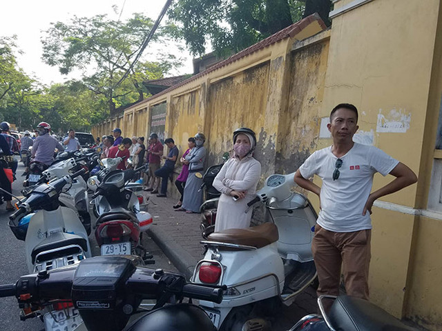 Phụ huynh học sinh đội nắng nóng xếp hàng đợi con tại các điểm thi.