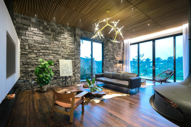 Gỗ Teak là một loại gỗ vốn dùng để đóng tàu biển có thể chịu được khí hậu khắc nghiệt ở miền Bắc Việt Nam, bản thân KTS là người am hiểu ngành chế biến gỗ, chứng kiến việc khai thác gỗ dẫn tới tàn phá những cánh rừng nguyên sinh hủy hoại môi trường, anh chủ động lựa chọn gỗ Teak từ rừng gỗ tái sinh có đặc tính phù hợp khí hậu địa phương mà quá trình khai thác lại không tác động tới môi trường. (Trong ảnh: Không gian phòng khách ở tầng 1)