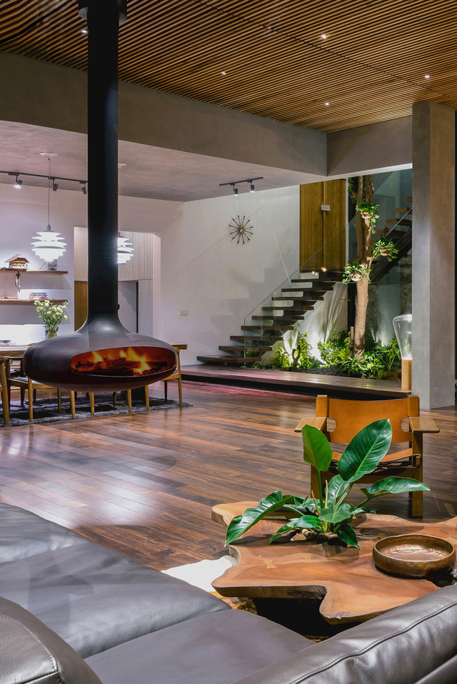 Giữa không gian phòng khách là một lò sưởi thép thả từ trần của Gyrofocus, một giải pháp sưởi cho mùa đông lạnh của miền Bắc Việt Nam nhưng cũng là một biểu tượng về phong cách Bắc Âu tại ngôi nhà này.