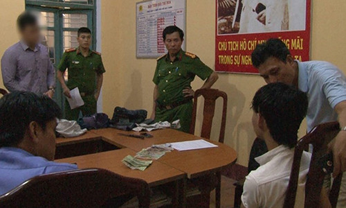 Cảnh sát lấy lời khai của Huy (áo trắng).