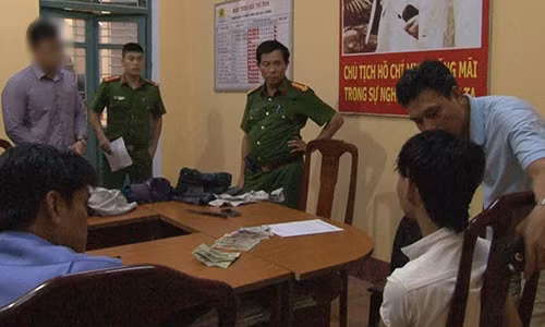 Cảnh sát lấy lời khai của Huy (áo trắng).