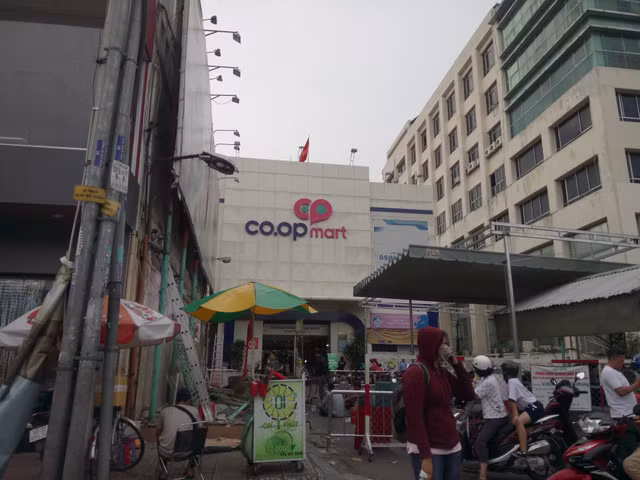 Khach ngo ngang truoc tin Co.opmart Dinh Tien Hoang dong cua