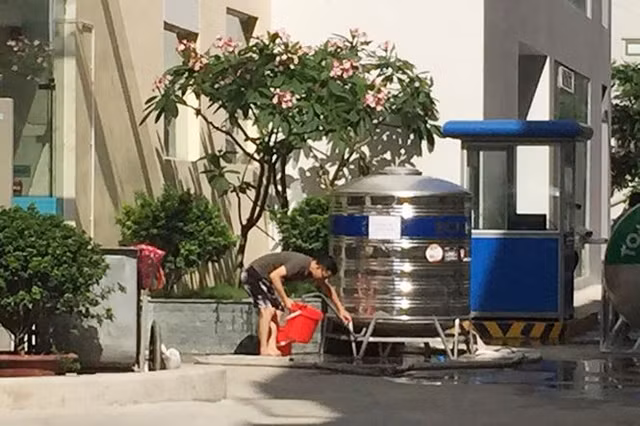 Cư dân Khu chung cư Xuân Mai Riverside "đội nắng" xuống sản lấy nước sạch về dùng.