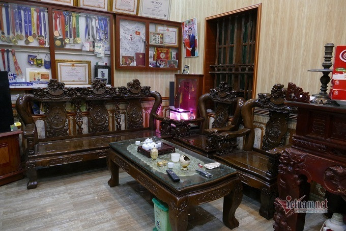 Phòng khách gọn gàng với bộ bàn ghế gỗ. Ảnh: Vietnamnet.