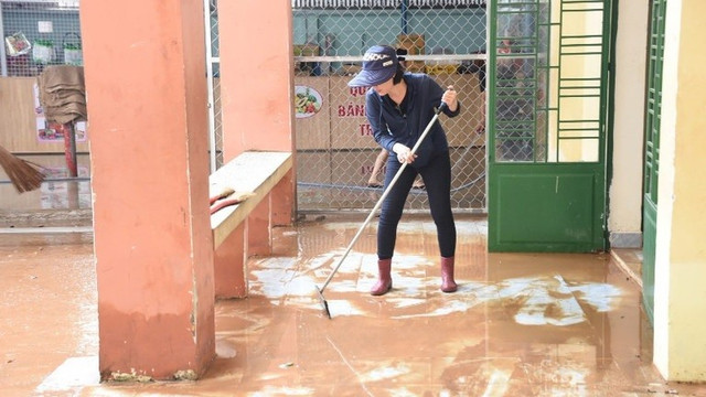 Giáo viên Trường trung học cơ sở Phước Tân 1 quét bùn ở hành lang lớp học sau lũ. 11-2030.jpg