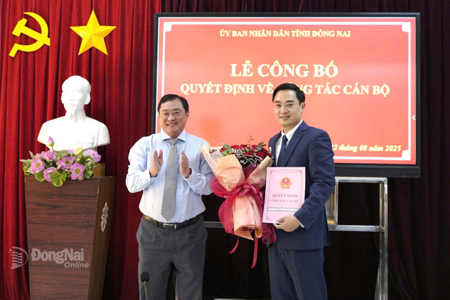 Tỉnh ủy viên, Giám đốc Sở Nội vụ tỉnh Đồng Nai Nguyễn Hữu Định trao quyết định cho ông Đặng Anh Tuấn, Phó Hiệu trưởng Trường đại học Đồng Nai. Ảnh: CTV