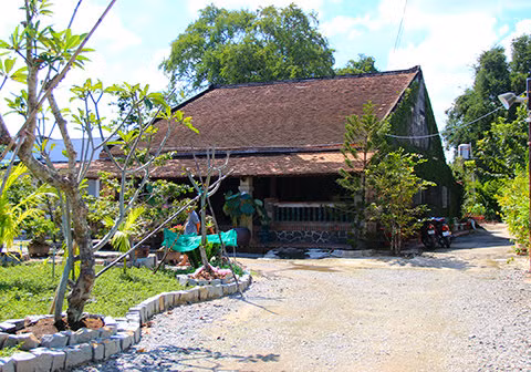 Căn nhà rộng khoảng 240 m2 (ngang 12 m, dài 20 m) gồm 1 trệt và gác. Sân vườn phía trước ngôi nhà được trang trí khá đơn giản. Sân nắng phía sau để lấy ánh sáng và gió tự nhiên. Ảnh: Vietnamnet.