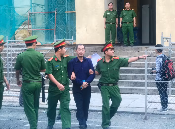 Bị cáo Trầm Bê được dẫn giải trở ra xe bít bùng để trở về trại tạm giam sau khi kết thúc ngày đầu tiên của phiên tòa.