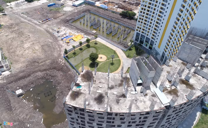 Một block khác chỉ là những khối bê tông cốt thép cao hàng chục tầng đã ngừng thi công. 2 block khác mới đổ cột trụ nhưng vắng bóng máy móc và công nhân. Ảnh: Zing.