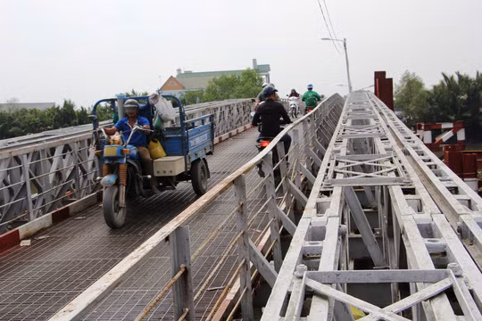 Vẫn là hình ảnh xe cộ nối đuôi nhau lưu thông theo cả 2 chiều trên cầu cùng những tiếng rung lắc. Độ dốc khá cao và mặt cầu trơn khiến các phương tiện không dám chạy nhanh. Có người vì sợ mà phải xuống xe dắt bộ