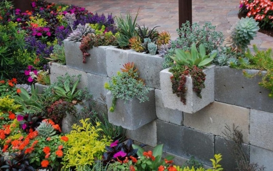 Bạn có thể sáng tạo một bức tường gạch bằng cách ốp các viên gạch lại với nhau tạo thành chậu cây, hoặc dùng loại gạch có ô trống để trồng cây vào bên trong. Những viên gạch vuông thành sắc cạnh tương phản với vẻ mềm mại của những thân cây và bông hoa tạo nên hình ảnh một bức tường gạch hoa vô cùng thú vị.