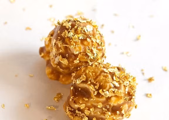 6.Bắp rang bơ tỷ đô Berco Nhà hàng Berco tại Mỹ đã cho ra mắt món bắp rang bơ dát vàng đắt nhất thế giới. Món ăn vặt này được làm từ hầu hết các loại nguyên liệu hảo hạng như bơ đặc biệt của hãng Vermont Creamery, vani của Nielsen Massey Bourbon, muối đắt đỏ đến từ đảo Laeso, Đan Mạch cùng vàng rắc 23K và đường hữu cơ. 1 xô bắp rang bơ 24 lít có giá 22 triệu đồng.