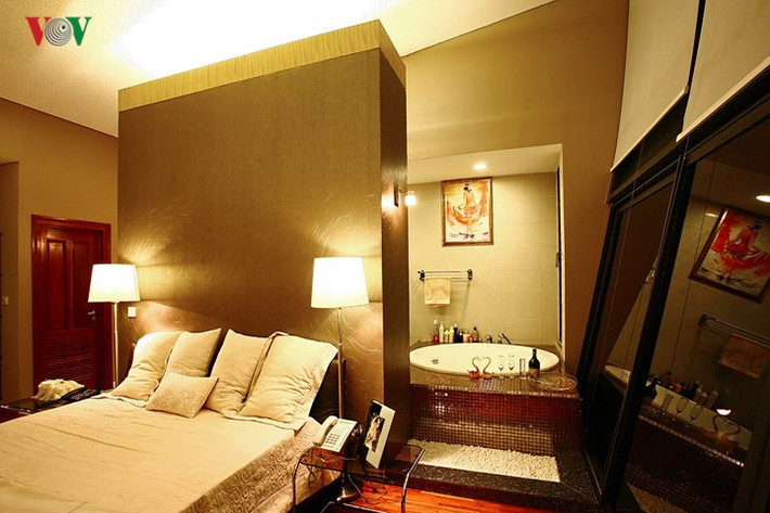 Phòng tắm nằm ngay trong phòng ngủ, không có ngăn cách và thoáng cả về bên ngoài qua vách kính lớn.