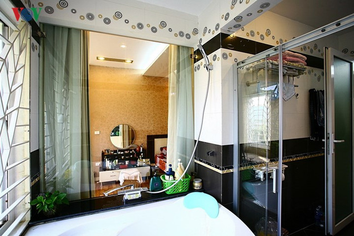 Mảng tường giữa phòng ngủ và phòng tắm được thay bằng vách kính. Sự kết nối này tạo nên nhiều điểm nhìn đẹp trong không gian.