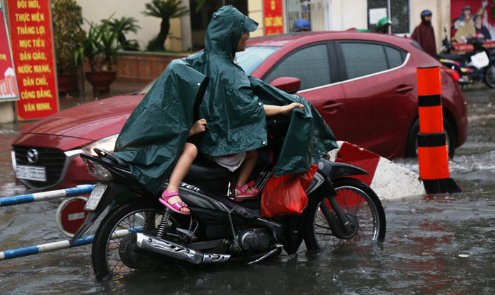 Các bậc phụ huynh một phen khốn đốn trong cảnh đón trẻ trở về nhà dưới cơn mưa tầm tã.