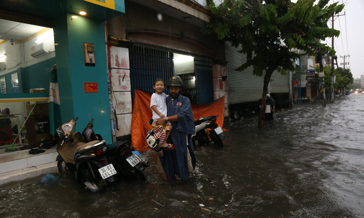 Nhiều bậc phụ huynh phải để xe ở vị trí cách xa vùng ngập để lội nước vào trường đón con.