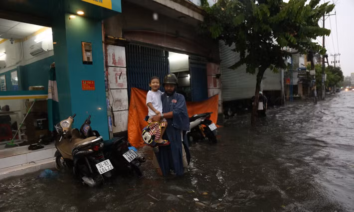 Nhiều bậc phụ huynh phải để xe ở vị trí cách xa vùng ngập để lội nước vào trường đón con.