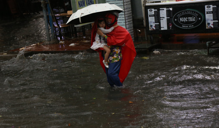 Nhiều bé tỏ ra thích thú khi được cha mẹ ẵm hoặc cõng lội qua biển nước...