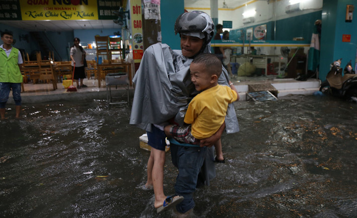Các trẻ nhỏ được cha mẹ cõng trên lưng hoặc ẵm lội nước về nhà. Có phụ huynh vừa ẵm vừa cõng một lần 2 đứa trẻ bì bõm lội nước cao tới đầu gối.