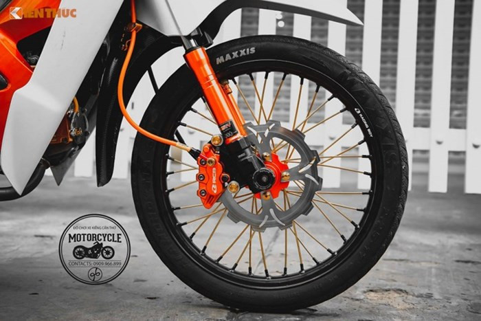 Dàn chân trước được chủ nhân độ nhẹ nhàng với bánh căm vàng và niềng nhôm Racing Boy đen cứng cáp đi cùng cặp lốp Maxxis , trang bị cụm phanh trước là heo Racing Boy và đĩa Apido, vỏ phuộc "sẹc tông" của thuơng hiệu Trusty.