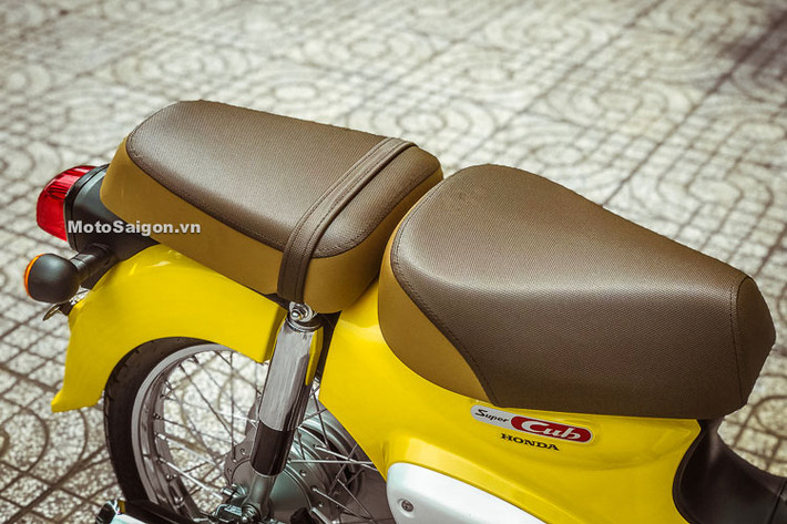 Chiếc xe vẫn giữ nguyên bộ yên đơn và giá đèo hàng giống như truyền thống của Super Cub nhưng được trang bị thêm yên mêm "sẹc tông" đi kèm. Bên dưới yên xe là logo Super Cub cách điệu được thiết kế mang hơi hướng cổ điển, đẹp mắt với mảng sơn đỏ trên nền mạ chrome.