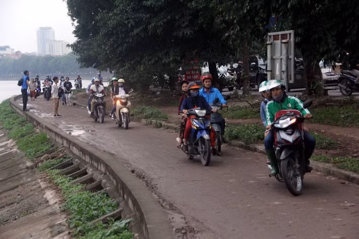 Tuyến đường Nguyễn Hữu Thọ ùn tắc nên người dân băng qua đường hồ Linh Đàm để thoát tắc. Ảnh: Trần Thường