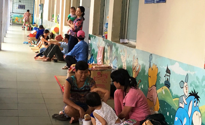 Người lớn, bệnh nhân trẻ em nằm ngồi la liệt ở các dải hành lang bệnh viện.