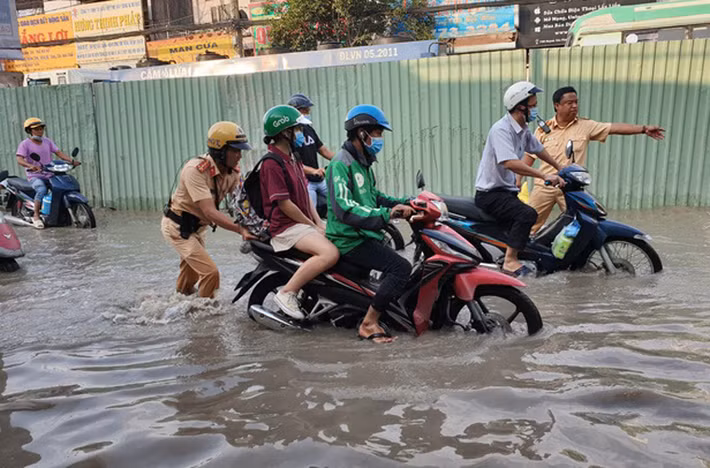 Cảnh sát giao thông giúp dân đẩy xe qua điểm ngập