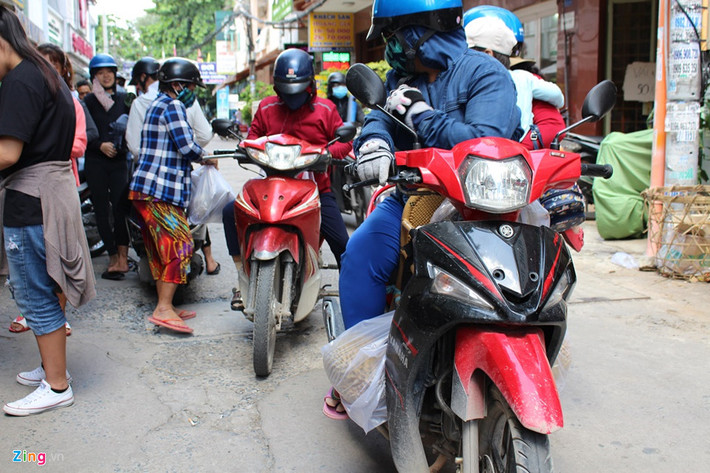 Con hẻm nhỏ trước cửa hàng luôn tấp nập người đến mua sầu riêng. Do xếp hàng chờ lâu, mỗi gia đình thường cử đại diện một người vào mua, một người trông xe. 