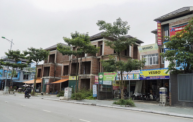 Khu nhà liền kề tại khu đô thị Yên Hòa (Q.Cầu Giấy) dù xây dựng xong phần thô nhưng không được hoàn thiện đã hơn chục năm nay. Dãy nhà gồm 36 căn liền kề, mỗi căn rộng khoảng 60 m2.