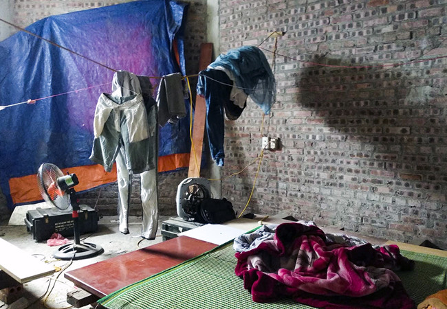 Trong những căn phòng chất đầy các vật dụng của đội thợ xây quanh các công trình xây dựng lân cận, được treo tạm bợ trên tường.