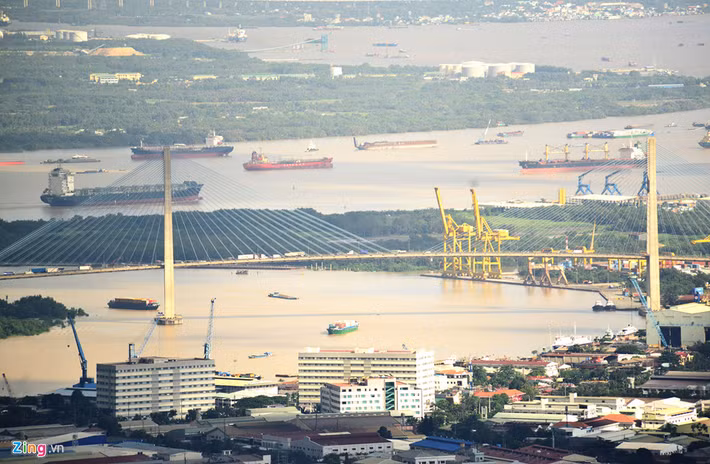 Khu vực cảng Tân Thuận nằm bên sông Sài Gòn với hàng chục nghìn container chất cao, tàu lớn nhỏ cập liên tục cảng bốc dỡ hàng hóa.